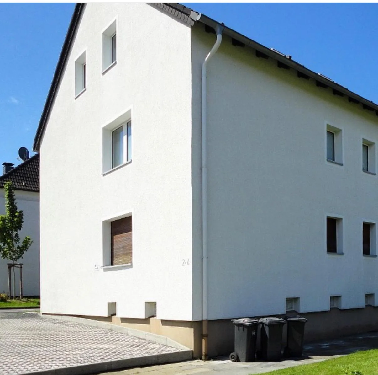 Dieselbe Hausfassade nach der Reinigung mit heller und gleichmäßiger wirkenden Wandflächen